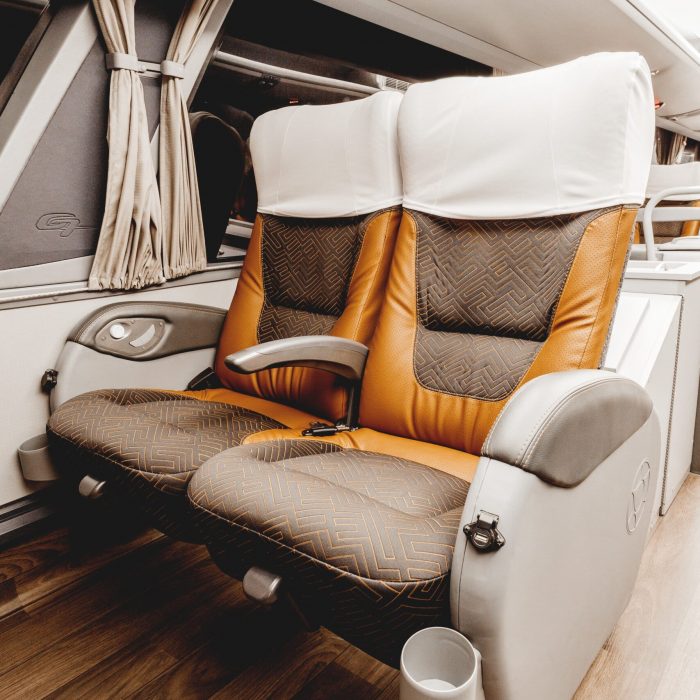 A vertical shot of an elegant car interior with leather seats and white curtains